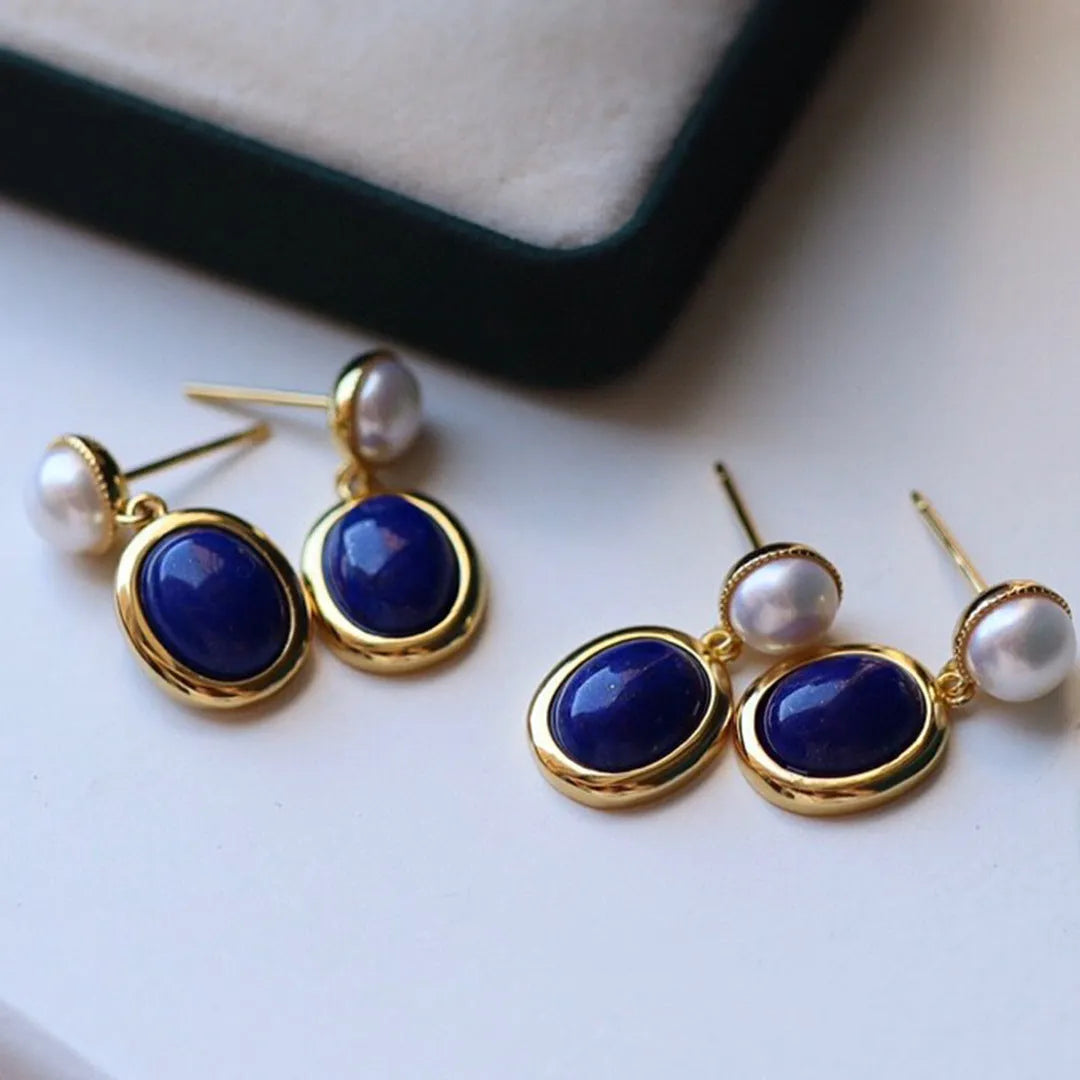 A pair of simple sterling silver earrings with a blue lapis lazuli pearl and auspicious patterns.