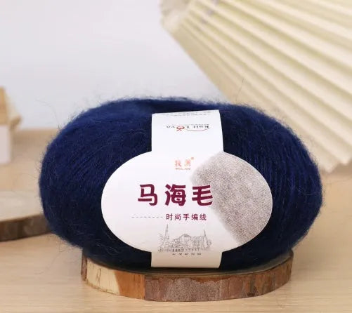A ball of mohair yarn in a selected colour next to a hand-woven scarf example, showcasing the DIY kit.