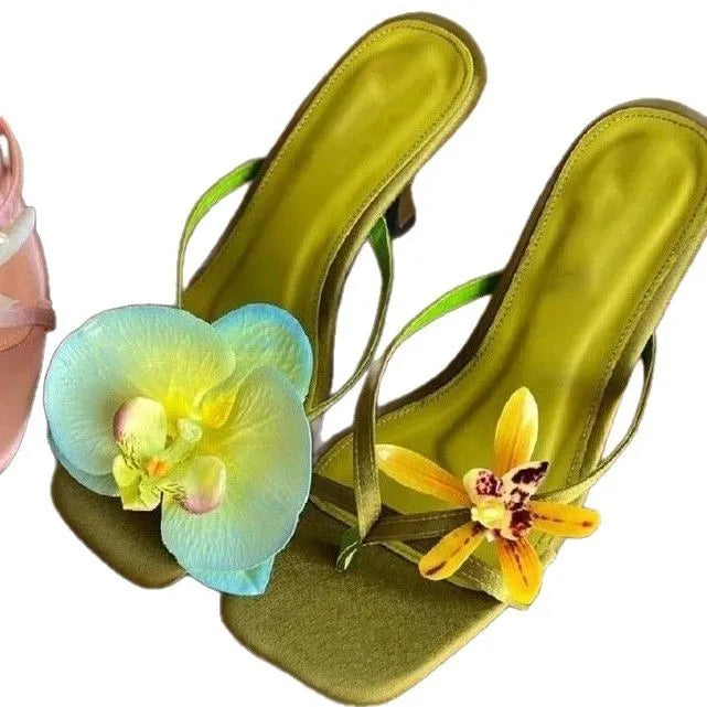 Handmade women's asymmetric flower sandals with high heel and square toe in black leather.