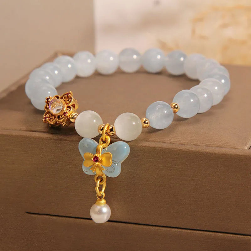 Women's adjustable bracelet with an aquamarine crystal butterfly pendant and rhinestone details on a metal chain.