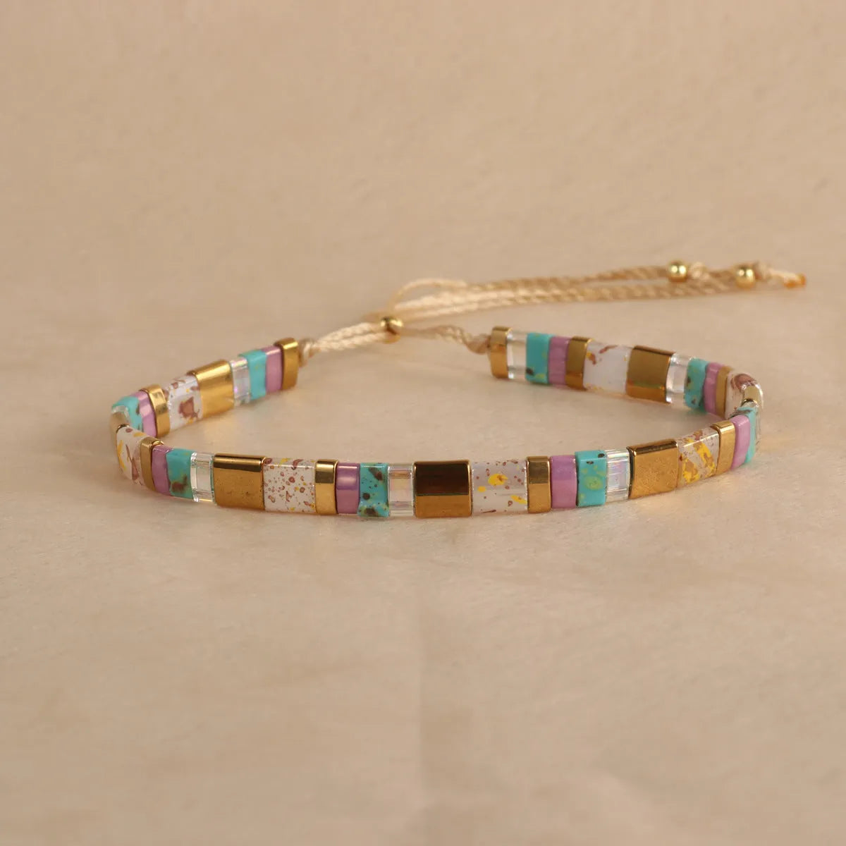 Geometric pull bead bracelet with glass and coloured glaze beads in round design