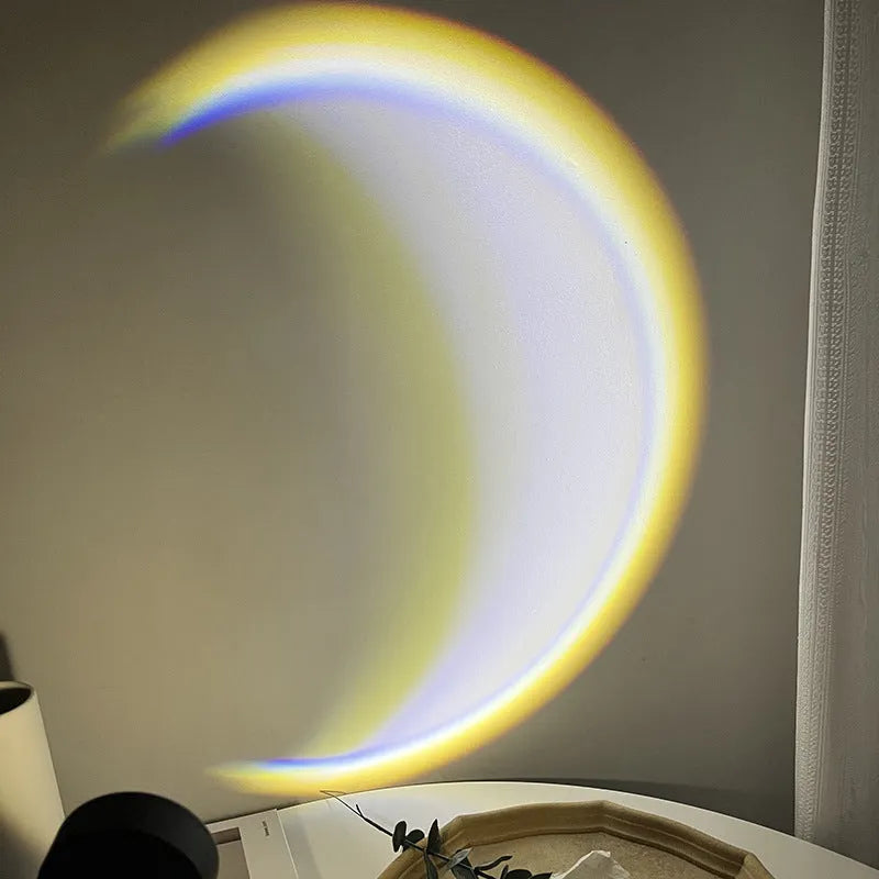 INS USB Moon Lamp LED projector on a table projecting rainbow light onto a wall.