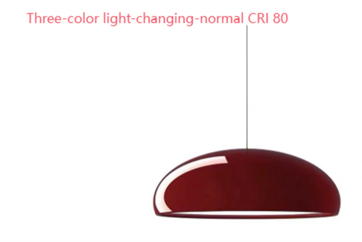 Danish-style iron pendant lamp with adjustable cord above a restaurant table.