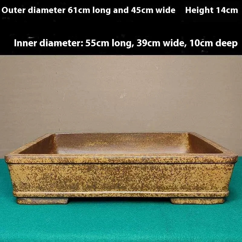Straight-sided shallow rectangular Yixing flowerpot made from unglazed purple clay on a wooden surface.