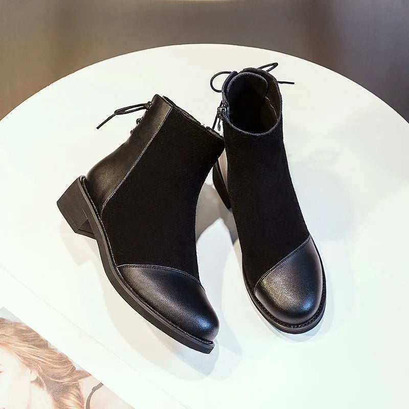 Black women's knee-high martin boots with side zipper and round toe on a rubber sole.