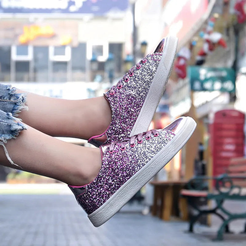 Women's black low-top casual shoes with sparkling sequinned upper and white laces.