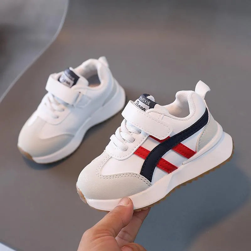 Children's solid-colour sneaker with Velcro strap, shown in beige, on a rubber sole.
