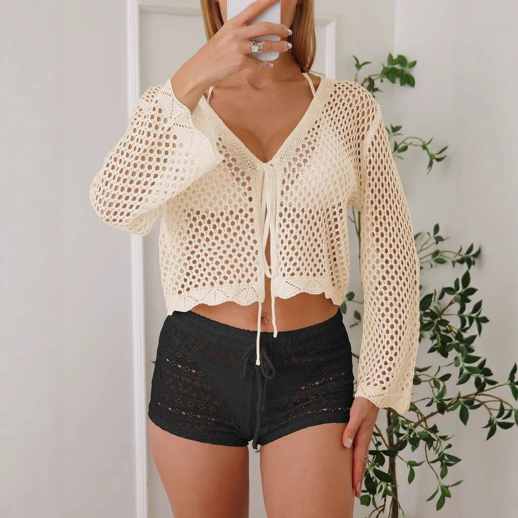 Short apricot hollow woven women's cardigan blouse with bell sleeves laid flat.