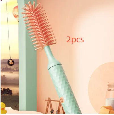 Pink and green electric baby bottle brush with rotating silicone head and USB charging cable