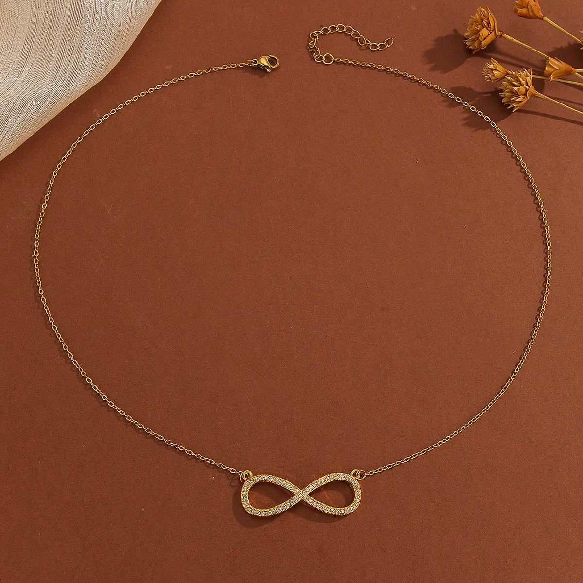 Gold plated copper infinity love pendant necklace with diamond accents and fine chain.