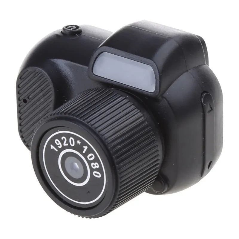Black retro-style mini digital video camera with small screen shown on a table.