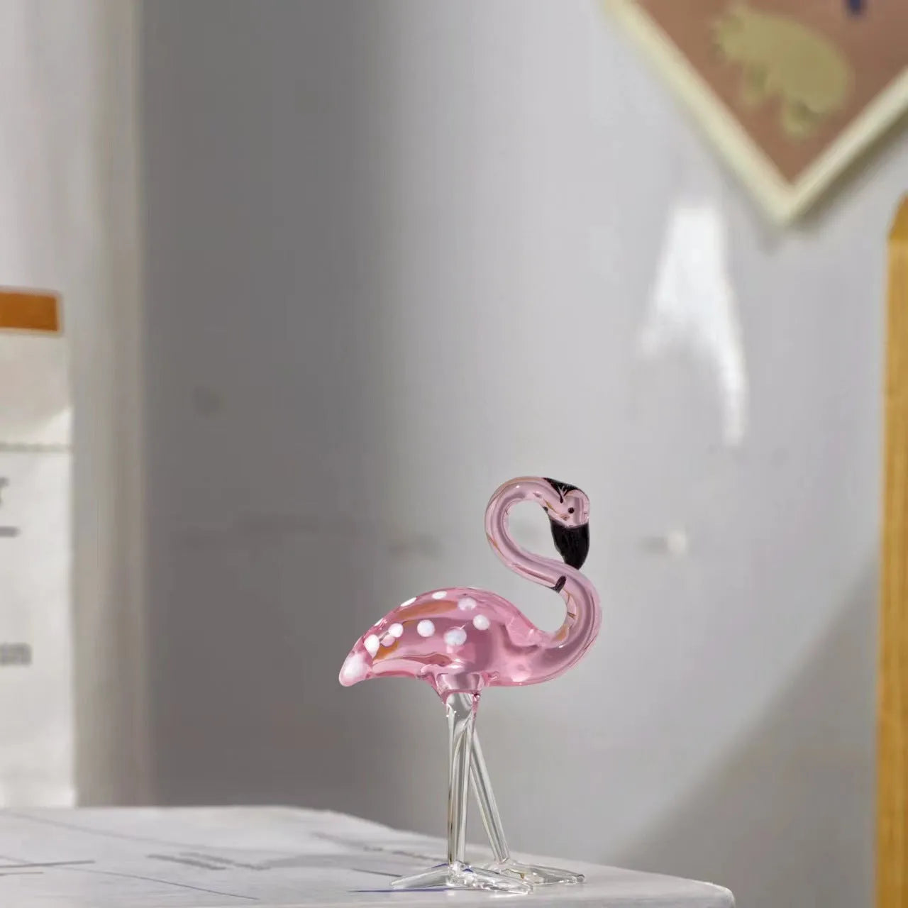 Pink crystal flamingo decorative figure on a table in modern style.