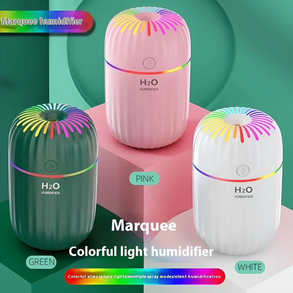 Mini green animal-shaped USB humidifier and aromatherapy diffuser on a desk next to a laptop.