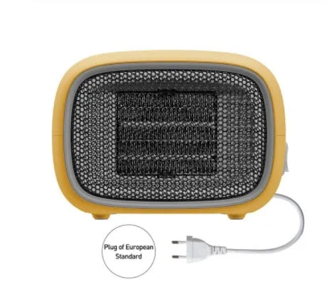 Compact green mini desktop heater with metal grille and EU plug on a wooden desk.