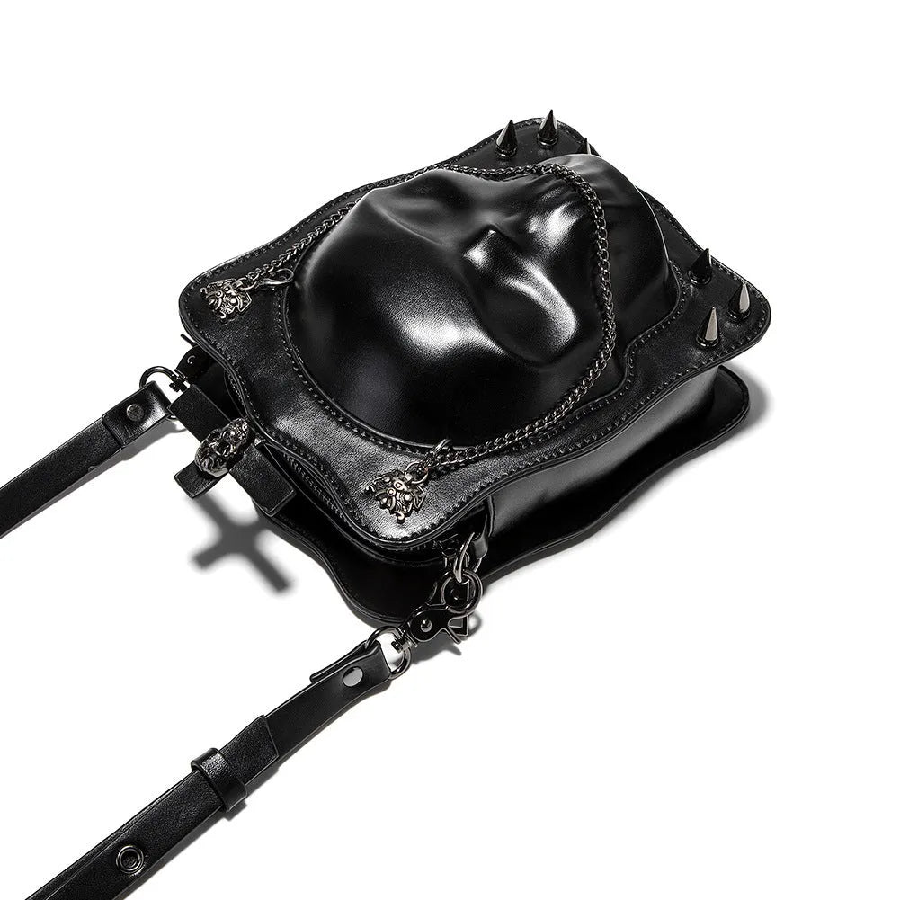 Black vertical square mini crossbody bag with embossed skull design, metal rivets, and chain strap.