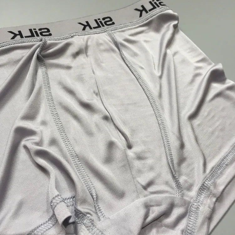 Men's loose fit silk shorts in navy blue, shown from the front on a mannequin.