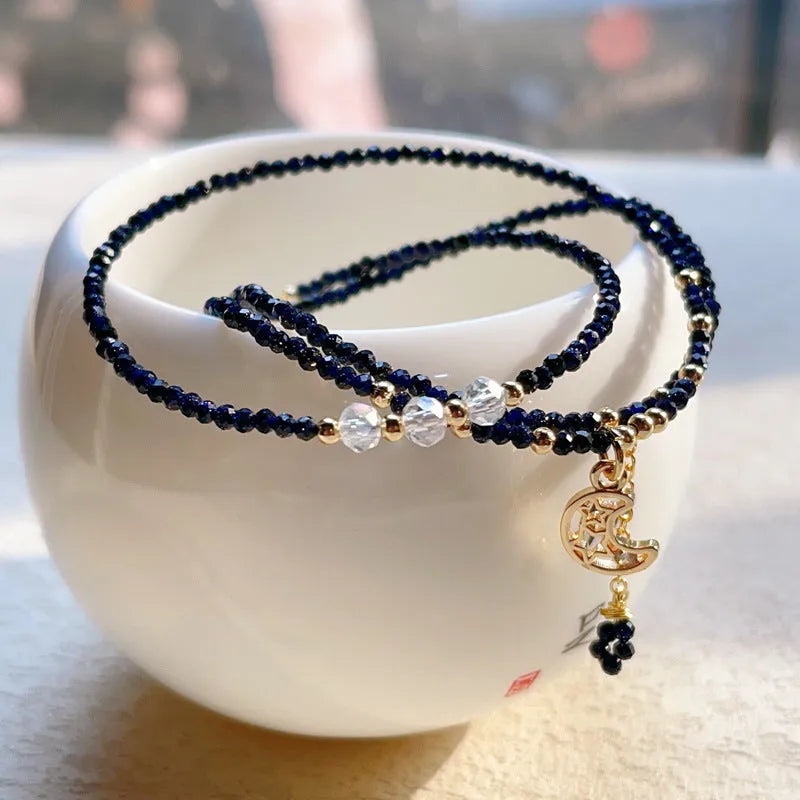 Women's three-ring layered bracelet with blue san stones in gold-toned settings, showing adjustable clasp