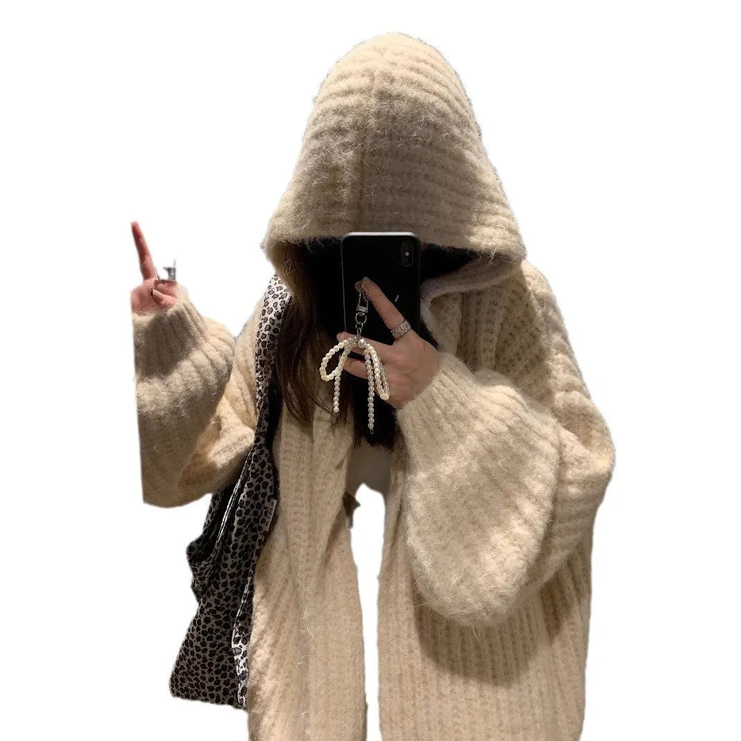 A woman wearing a thick, dark grey hooded cardigan with a loose, longline fit.