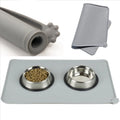 Grey silicone pet food mat with raised edges on a tile floor