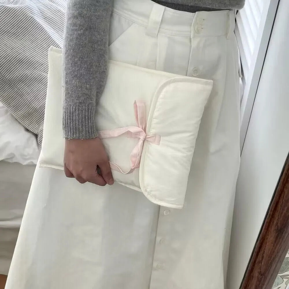 Black and white quilted women's laptop bag with a ballet bow, showing striped pattern and laptop compartment.
