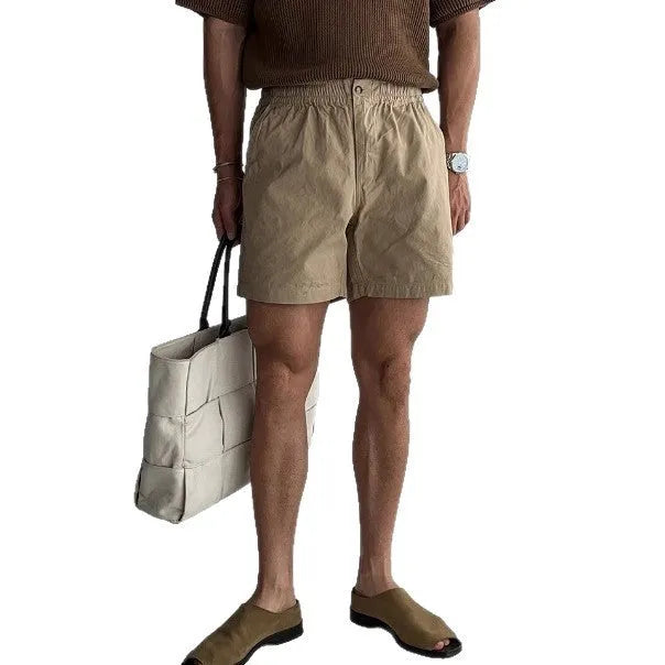 A pair of loose-fit cotton sports shorts in khaki colour on a mannequin, showing the casual summer style.