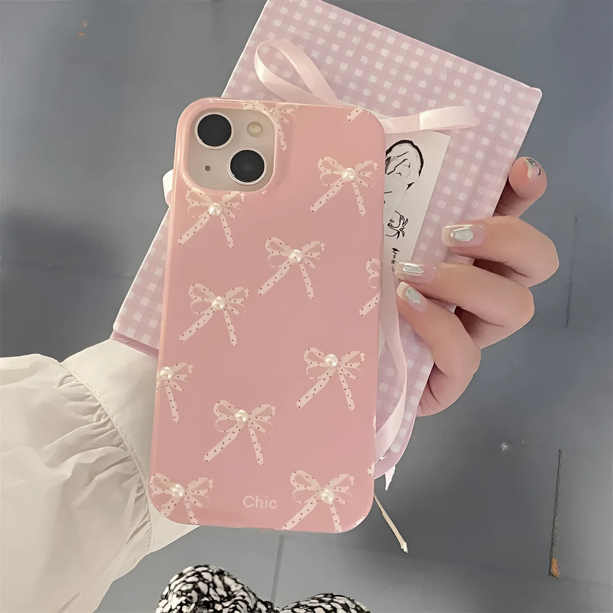 Pink soft TPU iPhone case with three-dimensional pearl dot bow, compatible with iPhone 11 to 15 Pro Max.