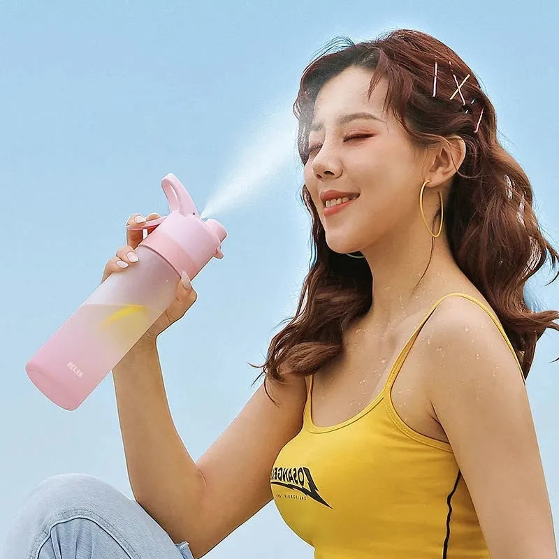 White plastic spray water bottle with handle strap and leakproof lid on a gym bag.