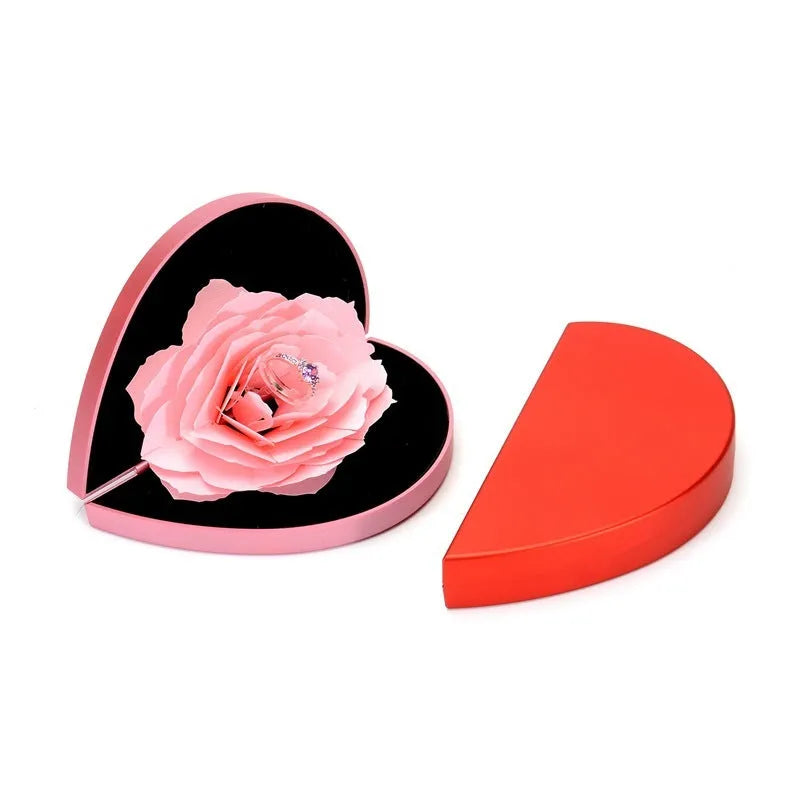 Red heart-shaped plastic ring box with a rose design and rotating 3D love text in the centre.