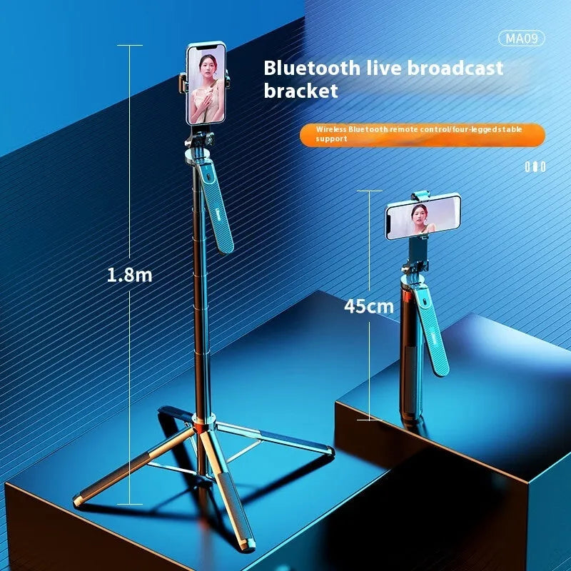 Bluetooth quadrupod selfie stick tripod with remote control, phone clamp, and four legs extended on a table