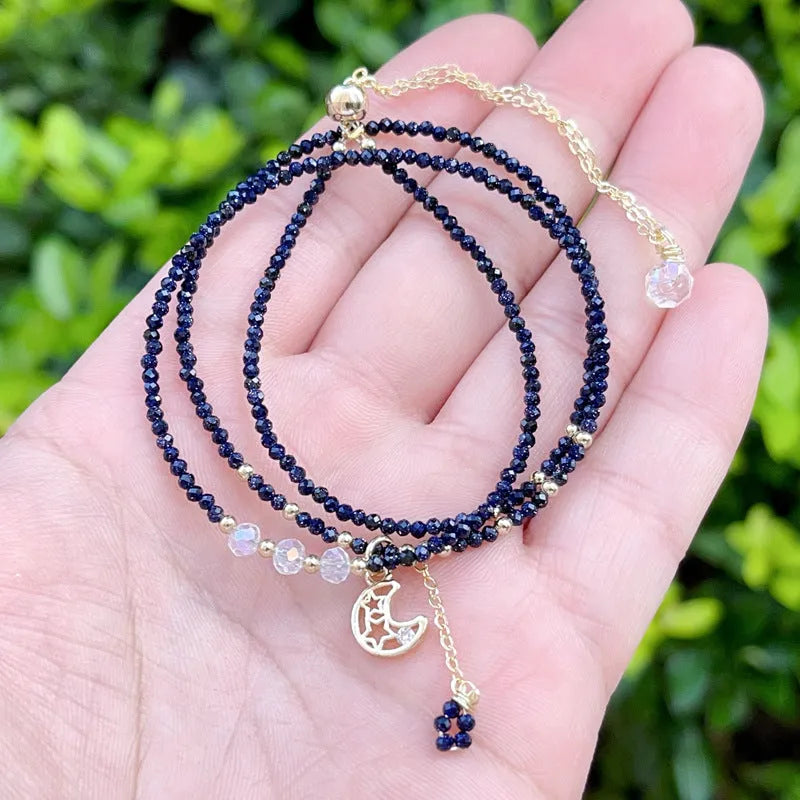 Women's three-ring layered bracelet with blue san stones in gold-toned settings, showing adjustable clasp