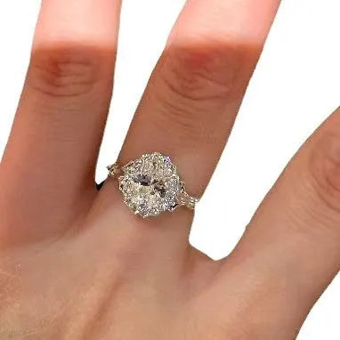Silver geometric ring with an elliptical diamond centre on a model's hand, showing adjustable opening.