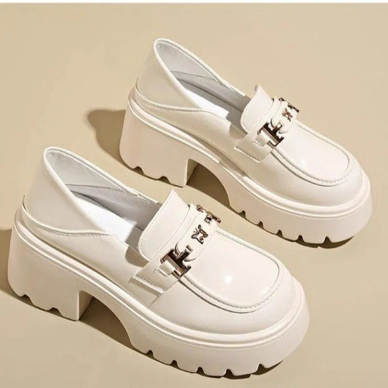 Black slip-on leather shoes with a chunky square heel and a skull pattern on the upper.