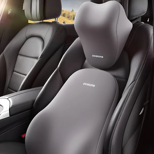 Black and beige memory foam car headrest pillow and lumbar support cushion on a vehicle seat.