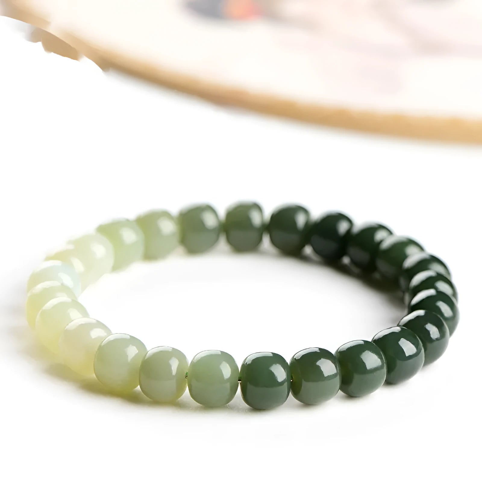 Natural Hetian jade bracelet with sunny water gradient colour on a wrist, showing oval beads.