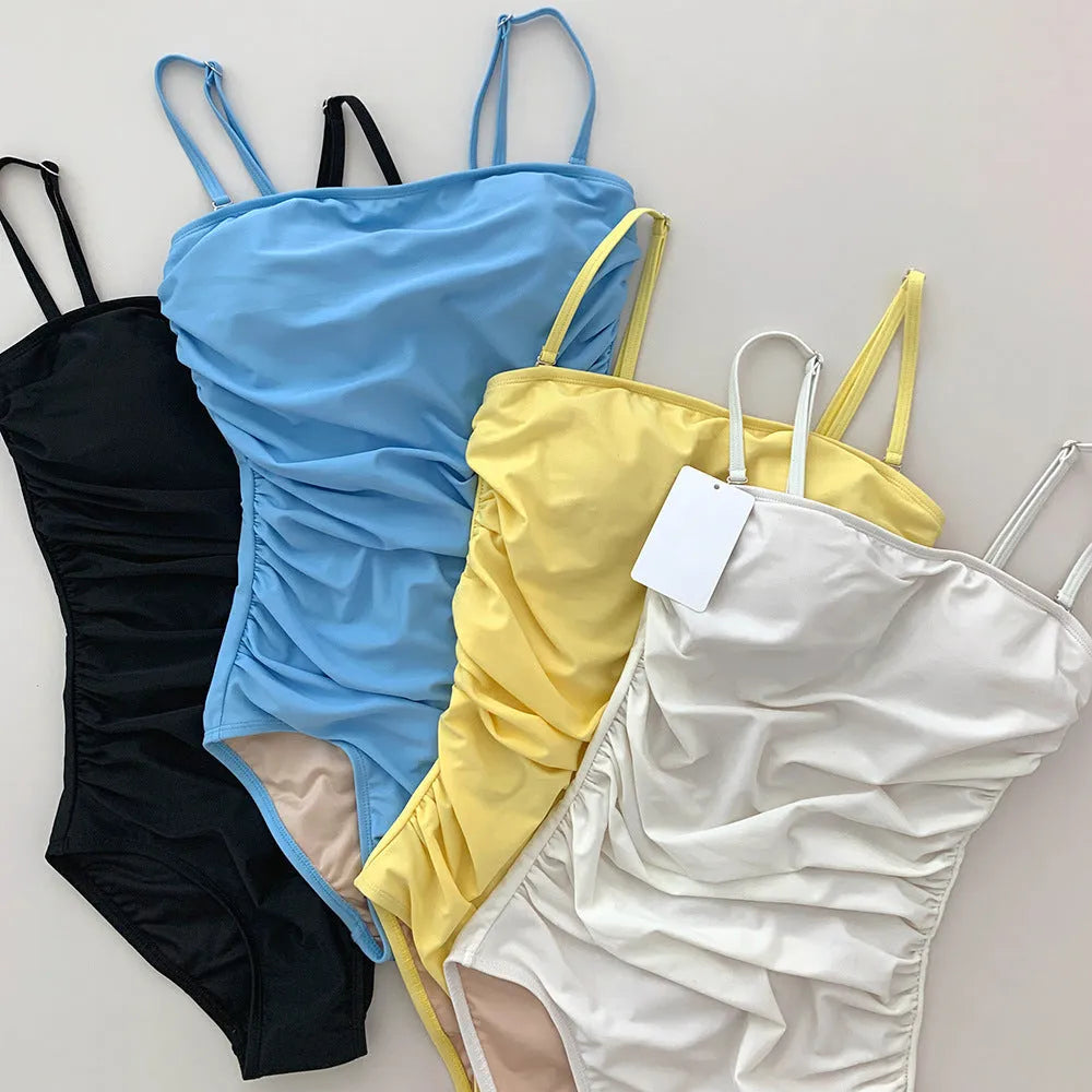 Sling style one-piece swimsuit with belly pleated detail in slim-fit silhouette