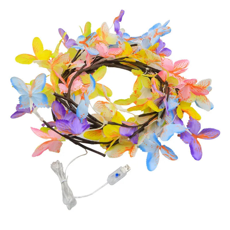Tall flexible LED rattan tree lamp with colour-changing butterfly decorations lit up.