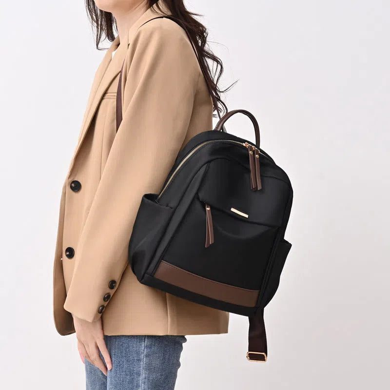 Women's large-capacity nylon travel backpack in black or milk tea colour with polyester lining and internal patch pocket.