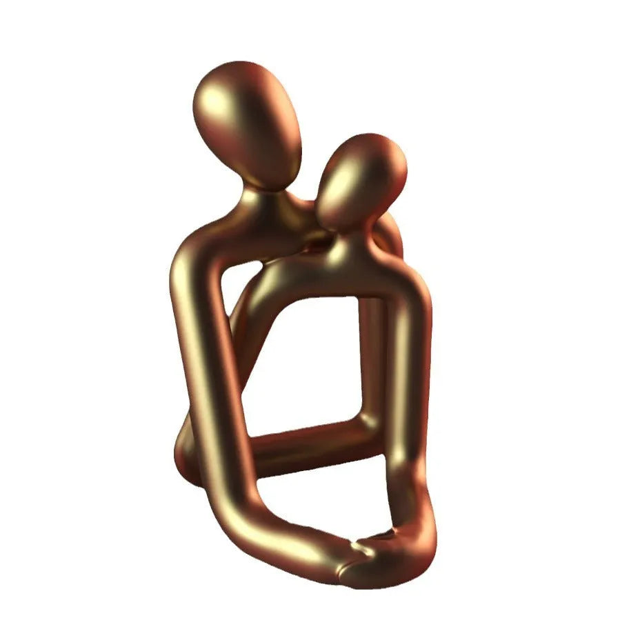 A modern minimalist loving couple resin statue in either milky white or gold finish, displayed on a surface.