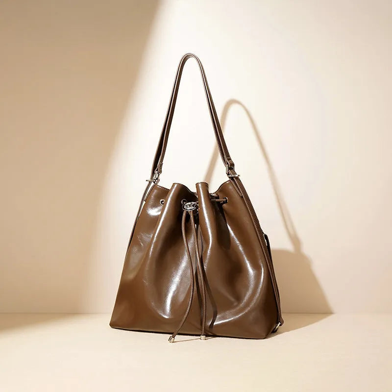 Genuine leather retro one-shoulder bucket bag in burgundy showing interior zipper and file pockets