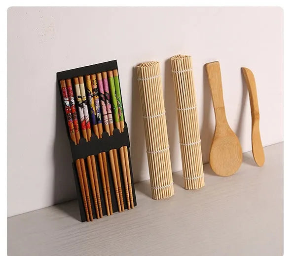 White sushi tool set with bamboo rolling mat and spatula on a kitchen counter