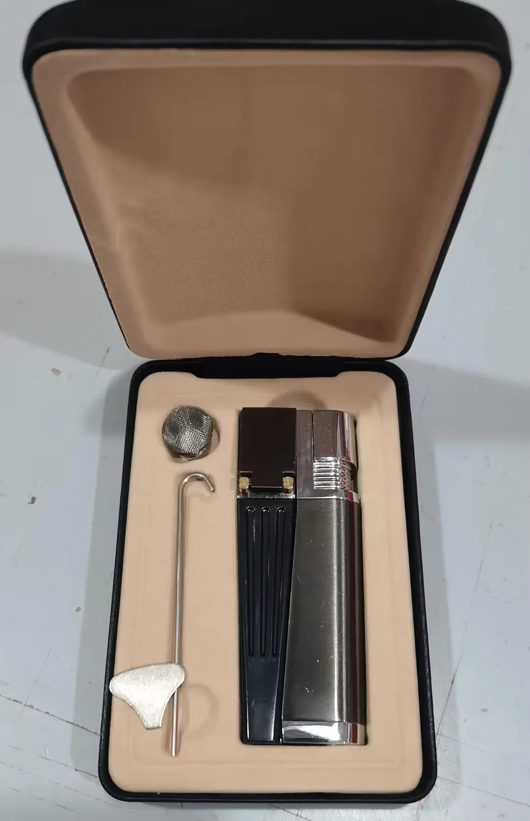 Silver foldable metal pipe lighter in open position showing flame mechanism and storage compartment.