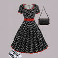 Multicolour polka dot dress with a square neckline, short sleeves, front zipper, and a pleated midi skirt on a hanger.