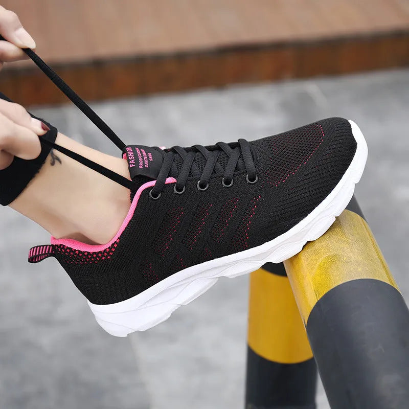 Women's sports running shoes in white with mesh and Flyknit upper, flat heel, and lace-up front