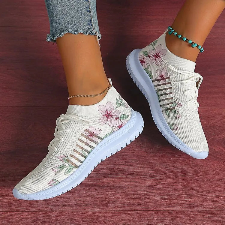 Women's milky white mesh flyknit running shoes with flat heel and rubber sole on grey background