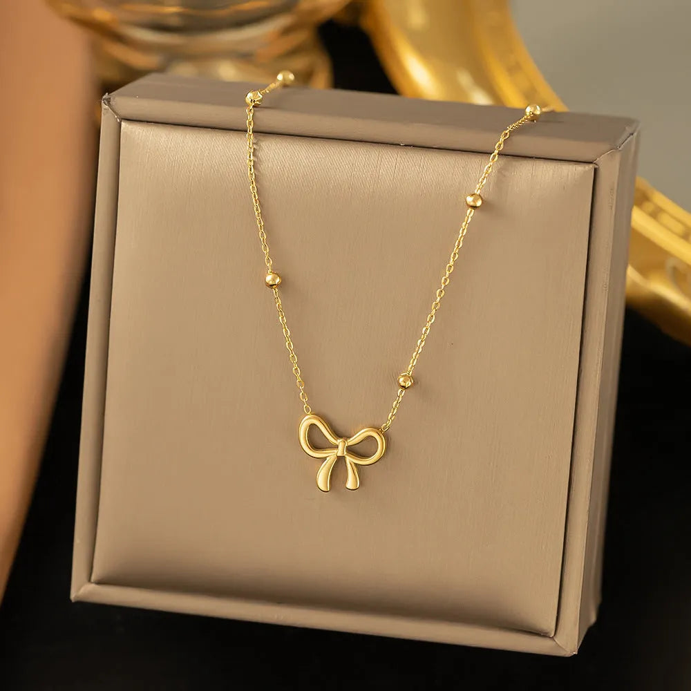 Gold electroplated titanium steel necklace with bow design and cross chain links