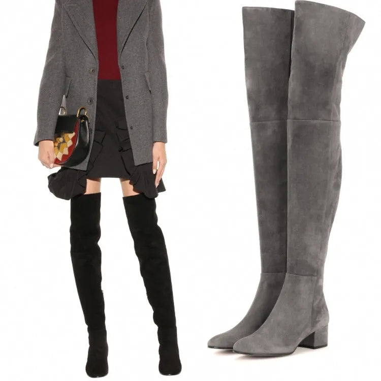 Grey suede women's over-the-knee flat boots with a pointed toe and low thick heel on a neutral background.