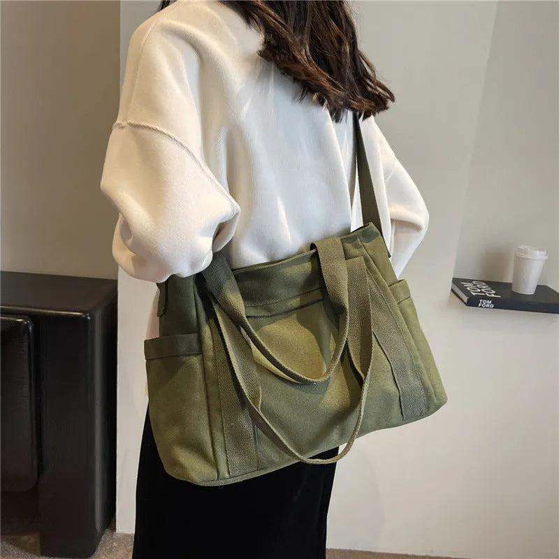 Large solid colour polyester canvas shoulder tote bag for women with outer pocket.