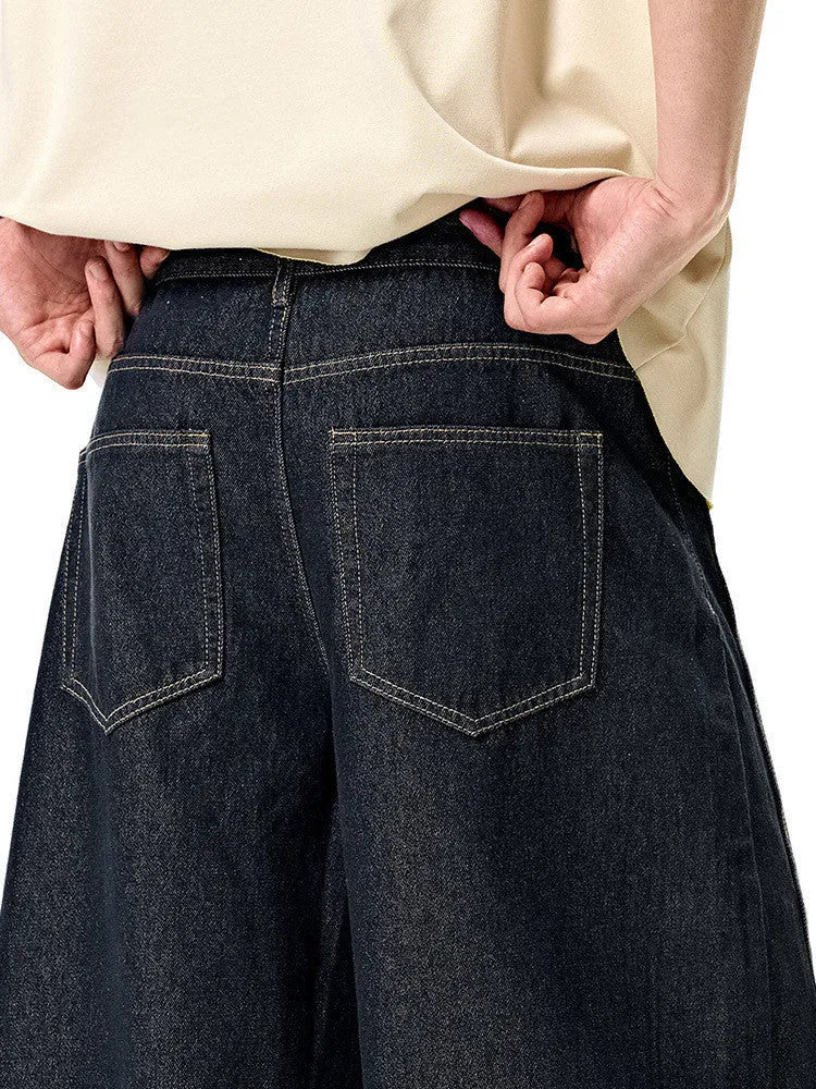 Men's wide leg denim trousers in original cow colour, laid flat to show mid-waist and relaxed fit.