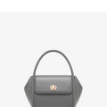A women's leather wing-shaped tote bag with a metal latch, shown in blue on a cross-body strap.