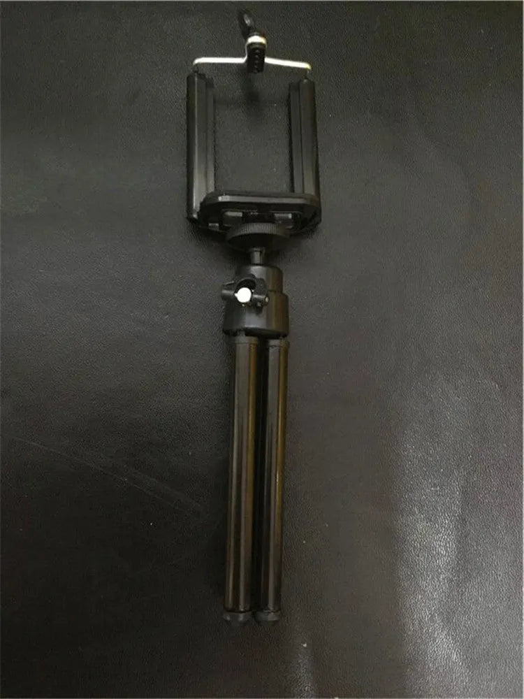 Black aluminium desktop phone holder with adjustable two-section bracket on a wooden desk